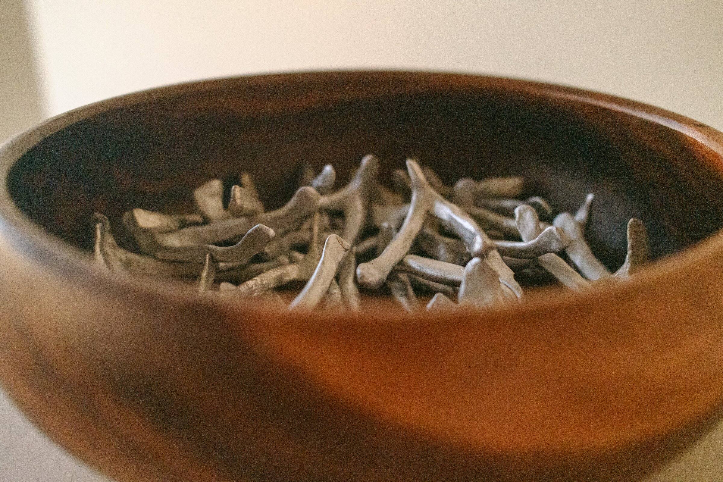 A turned wooden bowl filled with small pale shells.